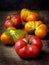 Tomatoes irregular shape of different varieties and colors on wooden background