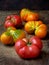 Tomatoes irregular shape of different varieties and colors on wooden background.