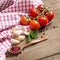 Tomatoes, mint, garlic and pepper on dark wood and dish towel