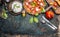 Tomatoes and mozzarella salad, preparation on dark aged rustic background, top view. Italian lunch