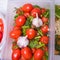 Tomatoes in a plastic container spices dill, parsley, pepper, cloves, Bay leaf, celery, close-up, background,  space copy