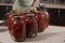 Tomatoes prepared for canning houses in glass jars