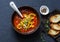 Tomatoes soup with roasted bell yellow pepper and goat cheese. Delicious vegetarian food on dark background