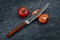 Tomatoes and a specialized chefs kitchen tomato knife on a gray grunge background close-u