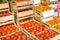 Tomatoes and tangerines in wooden boxes for sale at a market