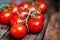 Tomatoes on the vine on rustic wooden background