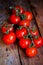 Tomatoes on the vine on rustic wooden background