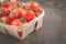 Tomatoes in a wattled basket/tomatoes in a wattled container on a dark wooden background, selective focus and copyspace