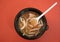 Tomyam soup in fast food wih plastic spoon top view on red background