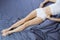 Tone woman body lying in bed at bedroom. Flat girl belly and perfect slim sporty figure. Sleeping and nap time. Relax on