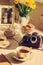 Toned background with Cup of tea, summer flowers, foto and vintage camera