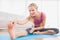 Toned blonde stretching on exercise mat smiling at camera