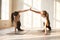 Toned girls give high five practicing yoga poses together