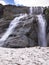 Toned image panorama of a large stepped waterfall with snow