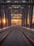 Toned image of the railway with sleepers and rail bridge on a background of multicolored sunset