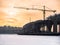 Toned image under construction Road Bridge over the frozen river with a large tower crane against the backdrop of a cloudy sky wit