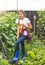 Toned photo of beautiful teenage girl digging soil in garden with spade