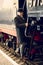 Toned photo of man in retro suit and bowler hat getting in train