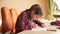 Toned photo of teenage girl listening to music and singing while doing homework