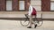 Toned photo of young man with bag walking with bicycle