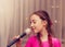 Toned portrait of cute little girl singing into a microphone