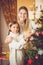 Toned portrait of smiling girl helping mother decorating Christmas tree