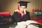 Toned portrait of thoughtful smart girl in graduation hat and go