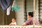 Tongan woman with a child sitting on a front porch of her house, Neiafu town, Vavau, Tonga