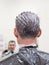 Toning gray hair on the man`s head in beauty salon