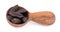 Tonka beans in wooden spoon, isolated on white background. Bean of Dipteryx odorata, cumaru or kumaru. Fresh aroma tonka beans