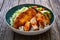 Tonkatsu - crispy Japanese pork chop with white rice and fresh vegetables on wooden table