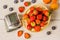 Tonometer, heart rate monitor to measure the body basket of strawberries on a white wooden vintage table blueberries and apricots.