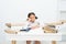 Too much to learn. Girl child tired exhausted sit at table near pile of books white background. Schoolgirl tired of