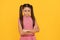 Too serious for her years. Serious school-aged child yellow background. School education