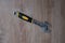 Tool adjustable wrench with the rubber handle on a blurred wooden background.
