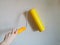 Tool, roller for smoothing wallpaper yellow. Paint roller with a red handle and a yellow smooth nozzle on a light