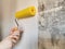 Tool, roller for smoothing wallpaper yellow. Paint roller with a red handle and a yellow smooth nozzle on a light background.