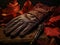 Tools of Autumn: Leather Gloves, Rustic Rake, and Crimson Leaves on a Deep Terracotta Canvas