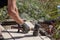 Tools of the craftsman. A professional paver worker laying patio slabs in a gravel bed using a professional paving hammer.