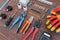 Tools for electrical work laid out on a wooden surface of brown