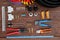 Tools for electrical work laid out on a wooden surface of brown. Top view