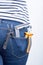 Tools for electrician in back pocket of blue jeans worn by a woman. Pliers, utters and bracket.