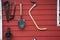 Tools and equipments farm gardening on red wooden wall of barn farmhouse for farmer use growing cultivating horticulture at meadow