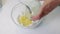 Tools and ingredients for making glazed curds. They are laid out on the table. A woman is mixing sugar with melted butter.