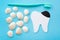 Tooth model with caries, toothbrush and seashells. Blue background. Flat lay. Top view. Benefits of minerals for dental