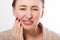 Tooth pain and dentistry. Macro face of middle age woman suffering about strong teeth pain, touching cheek by hand isolated on whi