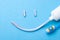 Tooth-paste in the form of a face with a smile. Tube of toothpaste and toothbrush on a blue background