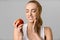 Tooth problems. Young woman having toothache, biting apple