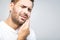 Toothache. Handsome young man suffering from toothache, closeup, touching his cheek to stop pain against white background