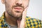 Toothache. Handsome young man suffering from toothache, closeup, touching his cheek to stop pain against white background